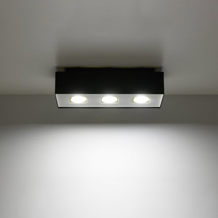Plafonnier Triple Raffiné noir projetant un faisceau de lumière vers le bas