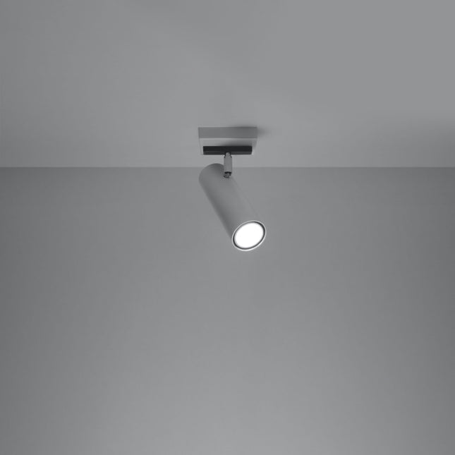 Plafonnier tube ajustable blanc allumé, faisceau dirigé sur un mur gris
