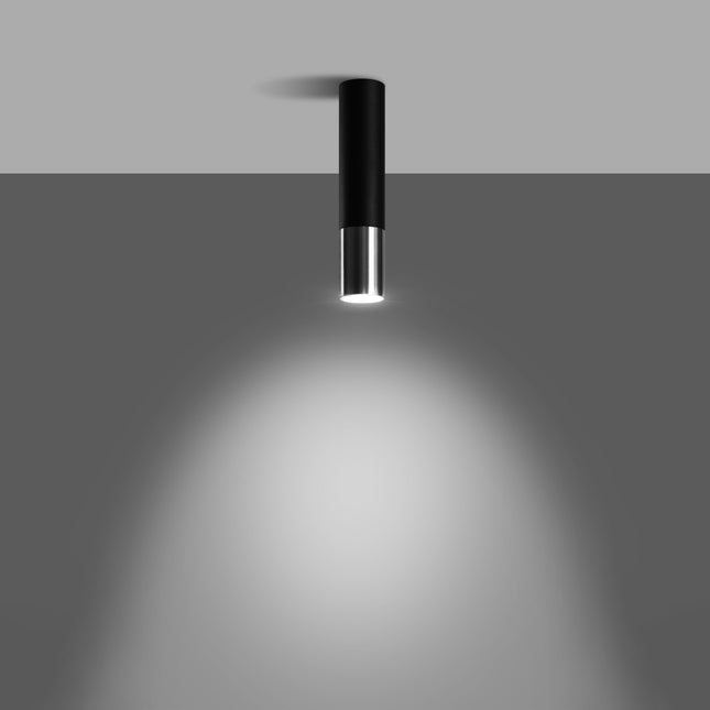 Spot plafonnier noir et chrome allumé projetant un halo lumineux au sol