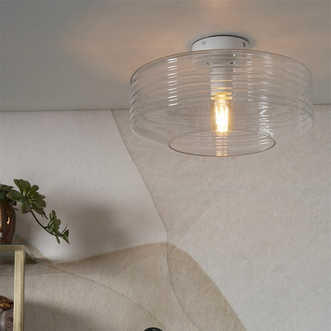Plafonnier Verona en verre strié transparent suspendu au plafond dans un salon lumineux