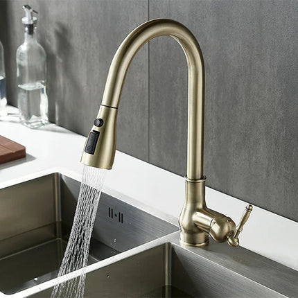 Robinet de cuisine à douchette extractible finition bronze au-dessus d'un évier inox, jet en marche