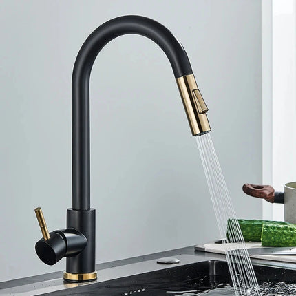 Grifo mezclador de cocina bicolor negro y dorado, chorro de agua sobre un fregadero negro