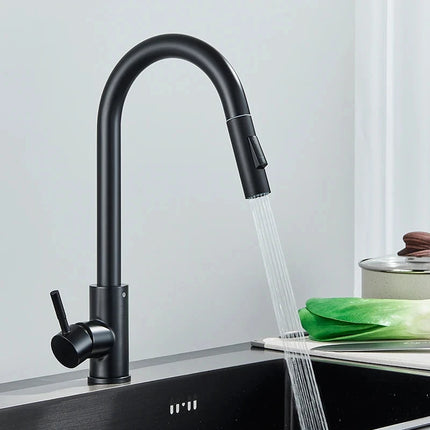 Grifo mezclador de cocina negro mate con caño alto, ducha de mano en chorro sobre un fregadero