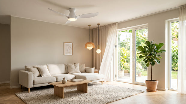 Ventilateur de plafond blanc flush mount et suspension design dans un salon lumineux ouvert sur jardin en été