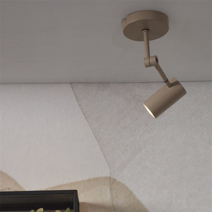 Spot de plafond Montreux fer sable oriente vers le mur, ligne epuree