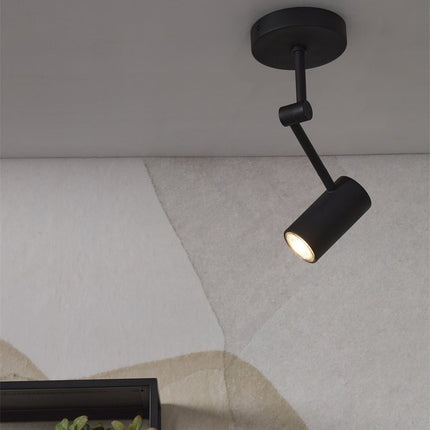 Spot plafonnier Montreux allumé, diffusant une lumière ciblée le long d'un mur texturé