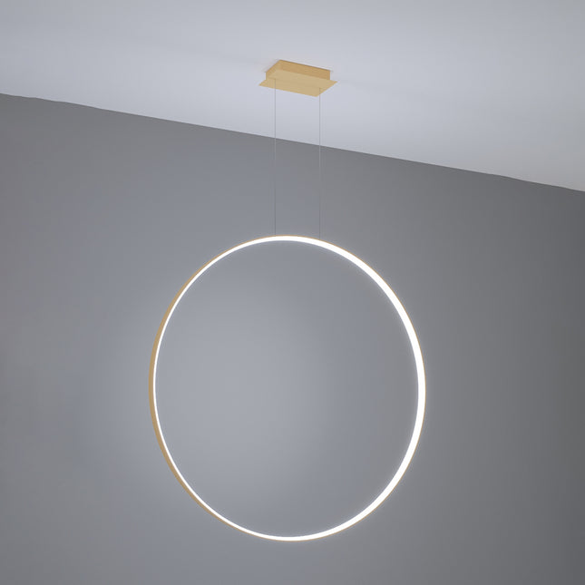 Grande suspension anneau doré Anneau Solis allumée, halo lumineux continu sur mur gris