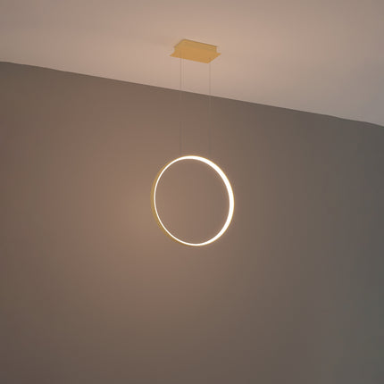 Suspension anneau doré Anneau Solis allumée, halo lumineux continu sur mur gris