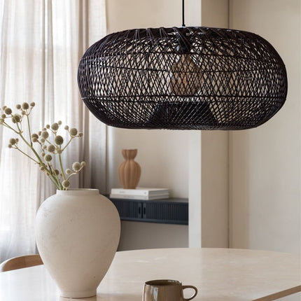 Suspension ovale Arizona en bambou bordeaux tressé éclairée, vase en céramique blanche en premier plan