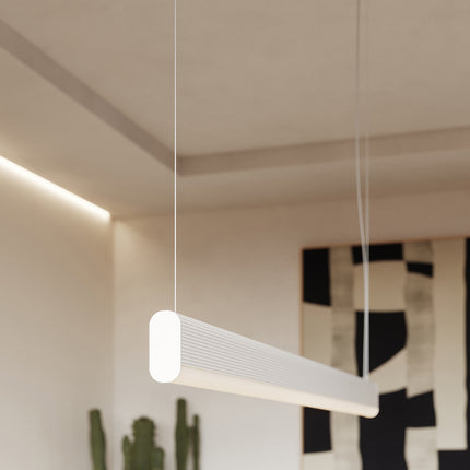 Suspension barre linéaire blanche allumée dans un séjour design aux touches graphiques