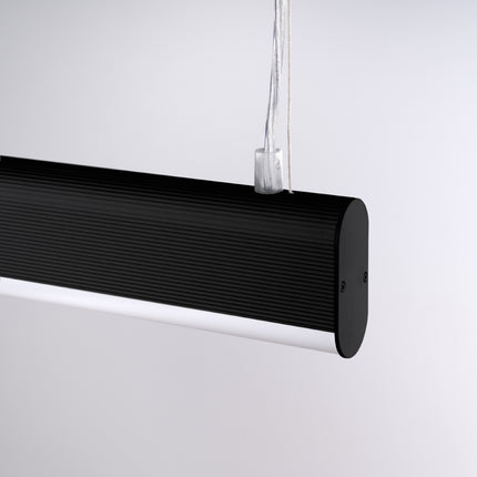 Gros plan de l'embout arrondi et de la face lumineuse de la suspension barre noire