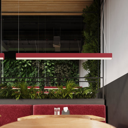 Suspension barre linéaire rose allumée au-dessus des tables d'un restaurant contemporain