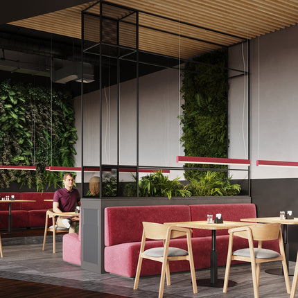 Suspension barre linéaire rose dans un café habillé d'un mur végétal luxuriant