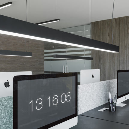 Suspension barre moderne LED noire allumée dans un espace de bureau moderne