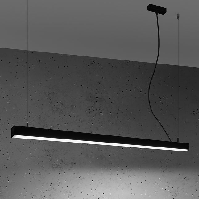 Suspension barre moderne LED noire 118 cm allumée de profil sur un mur de béton