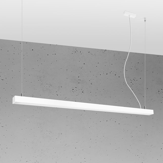 Suspension barre moderne LED blanche 150 cm allumée, profil aluminium sur un mur de béton