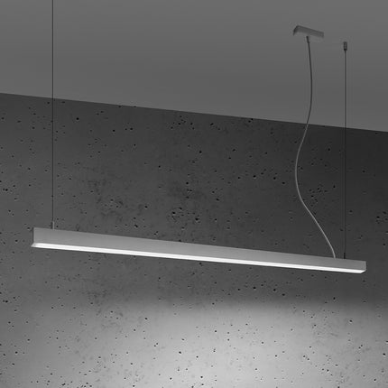 Suspension barre moderne LED blanche 150 cm allumée de profil sur un mur de béton