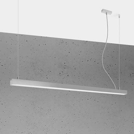 Suspension barre moderne LED grise 150 cm allumée, profil aluminium fin sur un mur de béton brut
