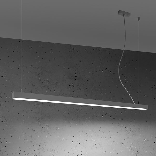 Suspension barre moderne LED grise 150 cm allumée de profil sur un mur de béton
