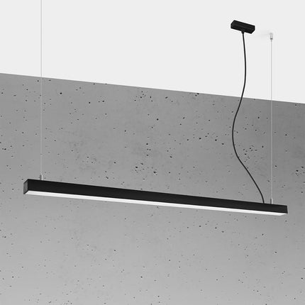 Suspension barre moderne LED noire 150 cm allumée, profil aluminium sur un mur de béton