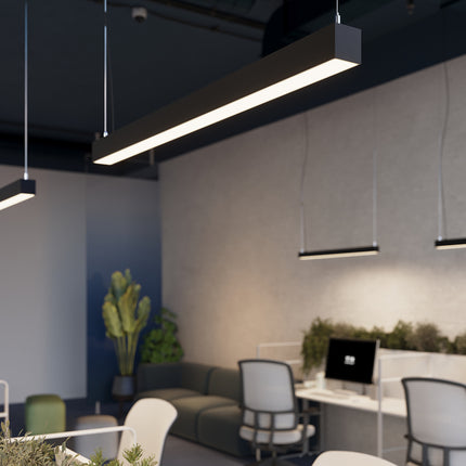 Suspension barre moderne LED noire allumée au-dessus d'un poste de travail