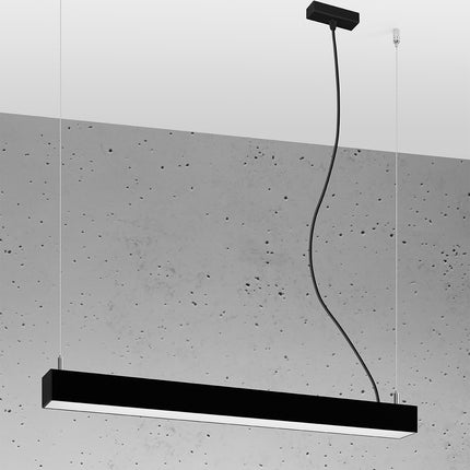 Suspension barre moderne LED noire allumée, profil aluminium sur un mur de béton