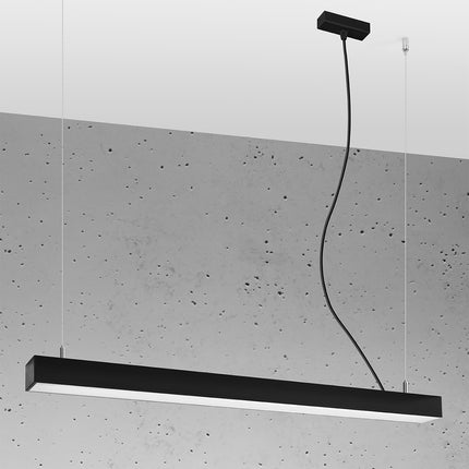 Suspension barre moderne LED noire 90 cm allumée, profil aluminium sur un mur de béton