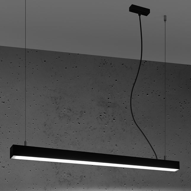 Suspension barre moderne LED noire 90 cm allumée de profil sur un mur de béton