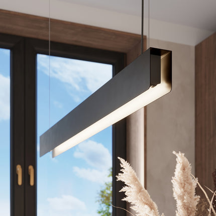 Suspension barre moderne noire allumée créant une ambiance chaleureuse en cuisine