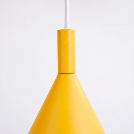 Suspension Bergen cône 25 cm jaune ambré sur fond coloré, vue de trois quarts
