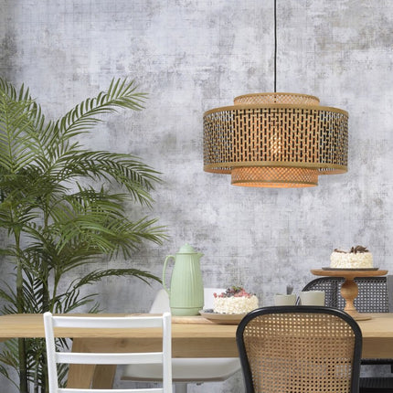 Suspension Bhutan en bambou tressé diffusant une lumière douce au-dessus d'une table à manger en bois