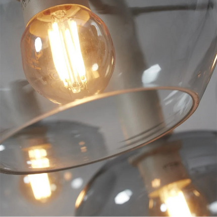 Vue rapprochée d'une ampoule filament chaude dans un globe en verre gris dégradé Bologna