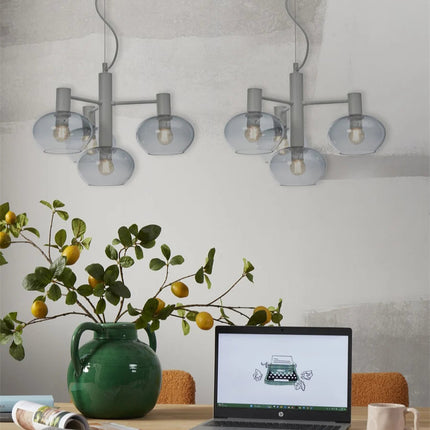 Deux suspensions Bologna 4 bras verre gris dégradé installées au-dessus d'une table de bureau