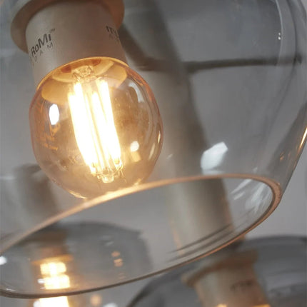 Détail de la douille et de l'ampoule filament dans un globe en verre gris de la suspension Bologna
