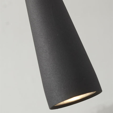 Suspension Bordeaux noire allumee dans une piece sombre