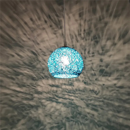 Suspension boule en fil de fer bleu projetant des motifs lumineux le soir