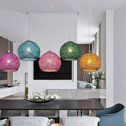 Cinq suspensions boule en fil de fer de couleurs différentes au-dessus d'une table
