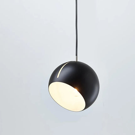 Suspension boule en métal noir mat allumée, faisceau LED chaud diffusé par l'ouverture inclinée
