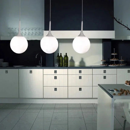 Suspension boule verre LED italienne au-dessus d'un îlot de cuisine