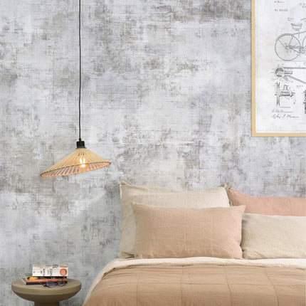 Suspension Bromo en bambou naturel installée en tête de lit dans une chambre aux tons neutres