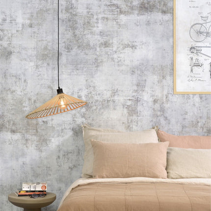 Suspension Bromo en bambou naturel allumée au-dessus d'une table de chevet, dans une chambre aux teintes beiges