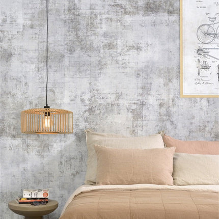 Suspension Bromo bambou naturel installée en chevet dans une chambre cosy, lumière tamisée et douce