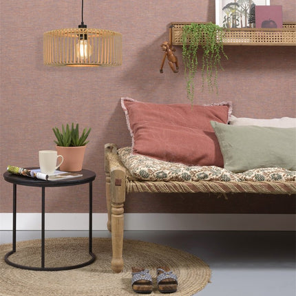 Suspension Bromo bambou naturel installée au mur au-dessus d'une banquette, ambiance bohème chic aux tons terracotta