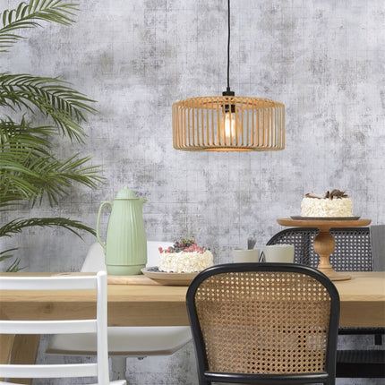 Suspension Bromo bambou naturel suspendue au-dessus d'une table à manger en bois, ambiance chaleureuse et conviviale