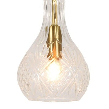 Suspension Brussels façon carafe en verre taillé transparent et doré, vue de face sur fond blanc