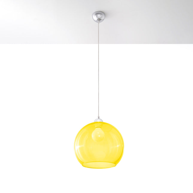 Suspension Bulle en verre jaune au-dessus d'une table à manger