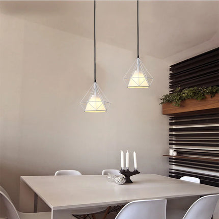 Deux suspensions cage diamant blanches au-dessus d'une table à manger claire