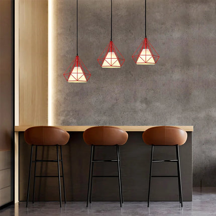 Trois suspensions cage diamant rouges au-dessus d'un bar avec tabourets en cuir