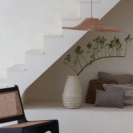 Suspension Cancun en rotin naturel dans une niche décorative avec fauteuil en cannage et coussins