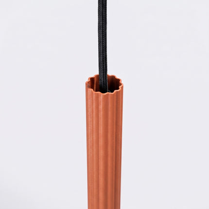Suspension Cannelée 1 Lumière acier ocre rouge sur fond coloré, vue de trois quarts